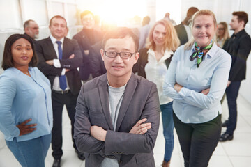 Wall Mural - young businessman standing in front of his colleagues .