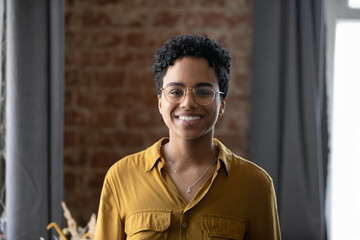 Wall Mural - Happy millennial Afro American business lady head shot portrait. Young Black short haired professional woman, leader, entrepreneur profile picture. Smiling confident employee looking at camera