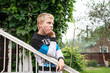 © Наталья Жукова - a boy stands on a wooden porch in the village and looks into the distance