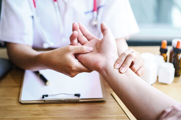 Female doctor taking male patient's pulse to check the heart rhythm.