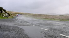 Audi R8 supercar hitting large puddle with big water splash in slow motion.