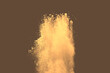 Abstract multicolored powder splatted on brown background, Freeze motion of color powder exploding. Yellow dust.