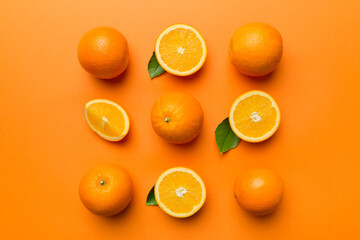 Wall Mural - Fruit pattern of fresh orange slices on colored background. Top view. Copy Space. creative summer concept. Half of citrus in minimal flat lay