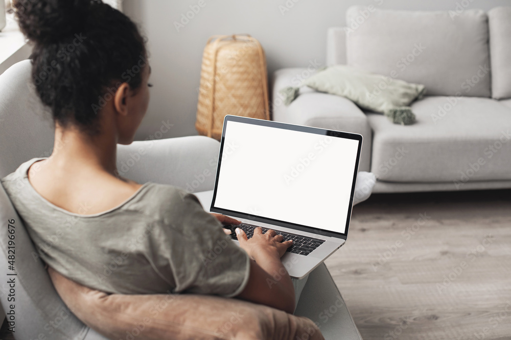 Young woman using laptop computer at home. Blank empty white screen ...