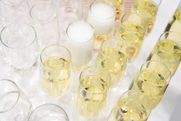 Champagne wineglasses with white wine on catering table bar