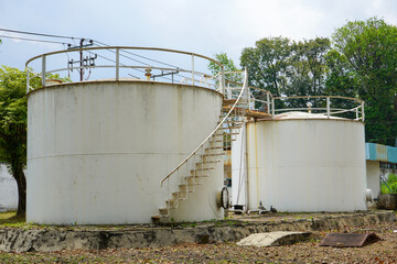 Water, gas and oil tanks in an industrial area. The tank was very large, circular in shape, high and there was a staircase going around it.