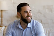 © fizkes - Cheerful bearded millennial man home head shot portrait. Cheerful guy, homeowner, tenant posing in apartment. Businessman entrepreneur looking away, laughing, smiling, thinking of future vision