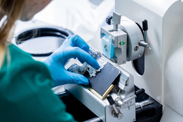 Laboratory assistant works on a rotary microtome section and making microscope slides