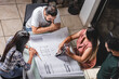 © STOCKEROcr - Grupo de personas empresarios analizando planos de construcción de un proyecto