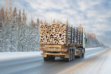 A Logging Truck Carries Lumber Along A Winter Highway.