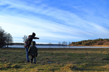 Adult pointing the way for a small kid. Nice day and landscape photo. Stockholm, Sweden, Europe.