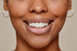 Close up portrait of young African-American woman smiling at camera demonstrating beautiful natural skin and white teeth smile