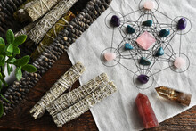 A Top View Image Of A Healing Crystal Grid Using A Sacred Geometry Grid Cloth And White Sage Smudge Sticks.