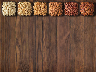 Wall Mural - various nuts and seeds on wooden table with copy space.  healthy food background