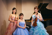 ヴァイリニスト、ピアニスト、フルーティスト3人の女性によるアンサンブル奏者の記念写真