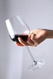 Fototapeta  - A woman holding a wine bottle and a wine glass.