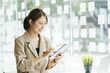 © PaeGAG - Asian business woman working with tablet computer in office.