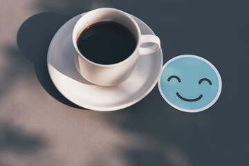 Wall Mural - Smile face paper cut and White coffee cup on gray table There is space on the side for design or product placement, Relaxing and refresh concept.