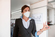 © Kostiantyn - Female flight attendant in medical mask standing in airplane