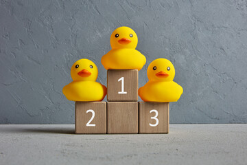 Rubber ducks ranked on a winner podium with numbers. Business competition or sports championship