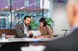 © Westend61 - Manager discussing with colleague over paper document at office