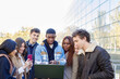 © Westend61 - Teenage boy pointing at laptop with friends on college campus