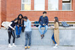 © Westend61 - Multiracial students discussing on project by wall on campus