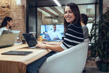 Smiling Businesswoman With Laptop In Meeting At Coworking Office