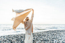 Woman Holding Blanket Enjoying At Beach
