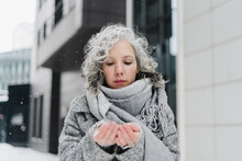 Woman With Gray Scarf Looking At Hands In Winter
