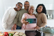 © Alessandro Biascioli - Happy Latin family having fun taking selfie with mobile smartphone while preparing healthy lunch in  kitchen at home