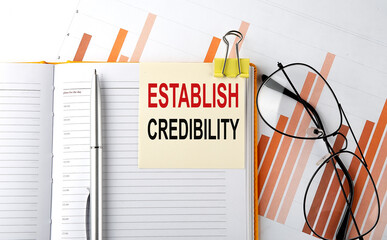 Text ESTABLISH CREDIBILITY on sticker on the notepad on diagram background