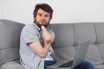 Handicapped disabled man with amputated two stump hands working typing on laptop at home looking at camera. Problem of adaptation to life people with disabilities. Independent Invalid person.