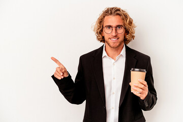 Wall Mural - Young caucasian business man holding coffee isolated on white background smiling and pointing aside, showing something at blank space.