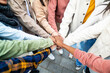 © Xavier Lorenzo - Close up view of united young people stacking hands in city street - Multiracial students putting their hands together for teamwork - Unity, community and cooperation concept.