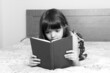 © gmstockstudio - Little girl reading a book at home