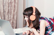 © gmstockstudio - Little girl using the laptop with earphones
