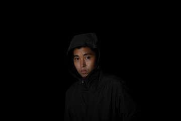 Man wear overcoat with hood on head on black background. Concept of fashion and stylish male.