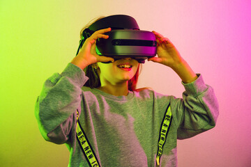 Wall Mural - excited child girl in vr headset during virtual reality experience at studio. emotional kid explorin