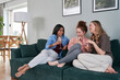 © gpointstudio - Three  female caucasian friends chatting and drinking wine at home