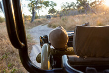 A Young Boy Sitting In A Jeep On A Sunrise Safari Drive. 
