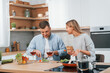 © standret - Using vegetables. Couple preparing food at home on the modern kitchen