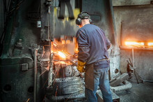 Rear View Of Engineer Forging Steel Parts In Hammer Press In Industrial Forge
