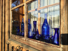 Vintage Blue Bottles In Wooden Window.