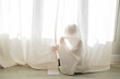© Sarah Rypma - Young child hiding behind a curtain at home