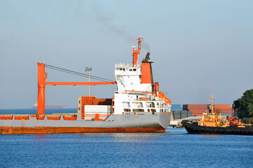 Wall Mural - Tugboat assisting bulk cargo ship