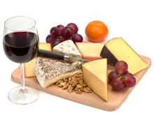 A Glass Of Red Wine And A Wooden Board With Cheese, Nuts, Grapes