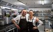© Halfpoint - Confident chefs colleagues standing with arms around and looking at camera in commercial kitchen.