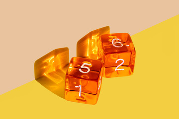 Orange plastic dice on a yellow background with the winning come out roll corresponding to a die with the number 5 and a die with the number 6 that add up to the number 11