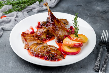 Wall Mural - Duck leg confit with berry sauce on white plate on grey table